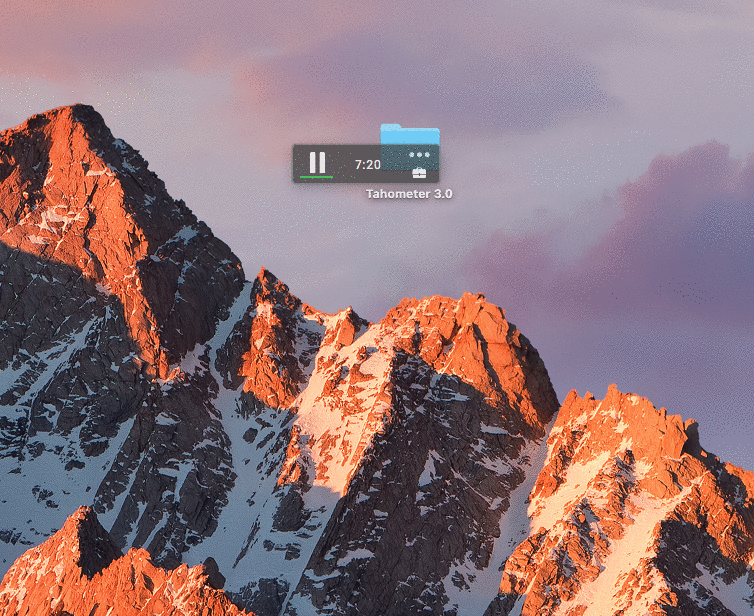 Snow-covered mountain peaks glowing orange at sunset with a file manager window overlay.