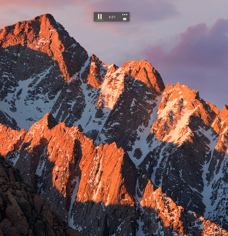 Snow-covered mountain peaks bathed in golden sunrise light with dark rocky slopes and purple sky.
